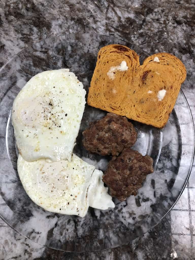 Toasted bread with over hard eggs & chicken sausage